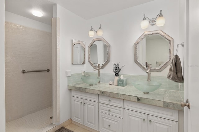 bathroom with vanity, tile patterned flooring, and tiled shower