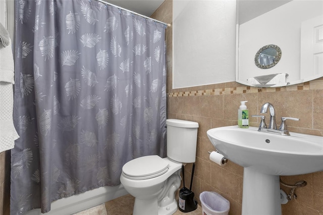 bathroom with tile walls, tile patterned floors, toilet, and a shower with shower curtain