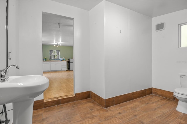 bathroom with hardwood / wood-style floors and toilet