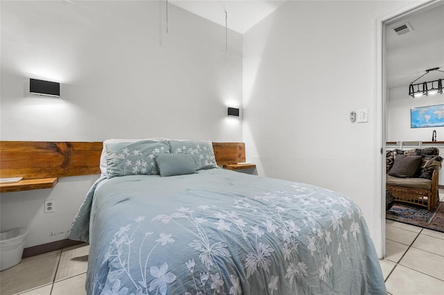 tiled bedroom featuring vaulted ceiling