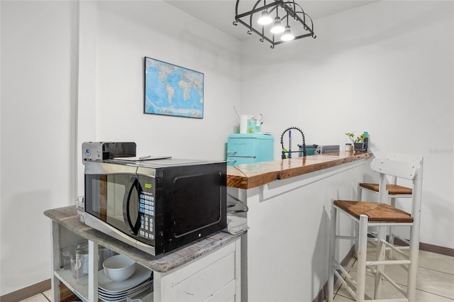 kitchen featuring pendant lighting, sink, white cabinets, kitchen peninsula, and a chandelier