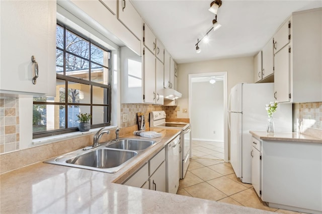 kitchen featuring white cabinetry, sink, light tile patterned flooring, and white appliances