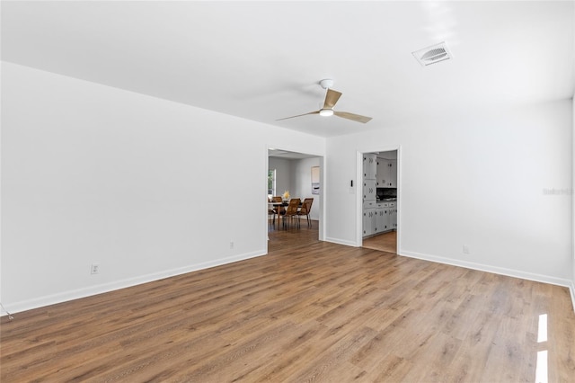 empty room with ceiling fan and light hardwood / wood-style floors