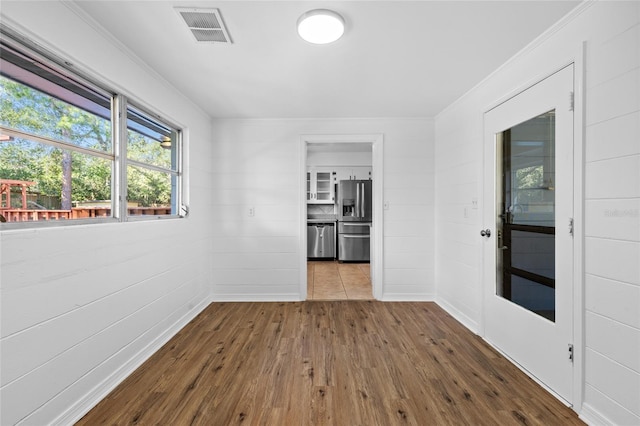 unfurnished room featuring hardwood / wood-style floors and crown molding