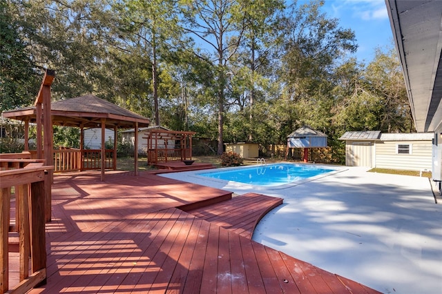 view of swimming pool with a storage shed, a gazebo, and a deck