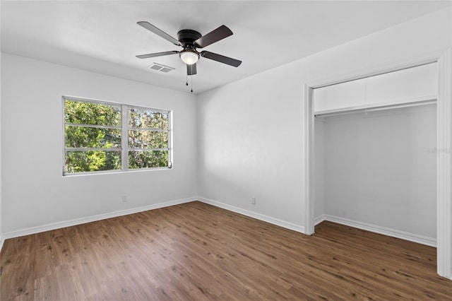 unfurnished bedroom featuring dark hardwood / wood-style floors, a closet, and ceiling fan