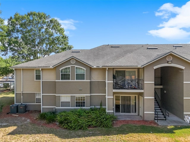 view of front of house featuring a front yard and central air condition unit