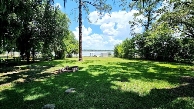 view of yard featuring a fire pit and a water view