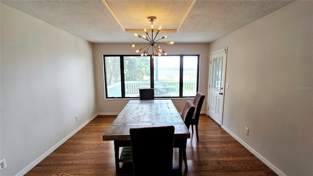 dining area featuring a textured ceiling, dark hardwood / wood-style floors, and a chandelier