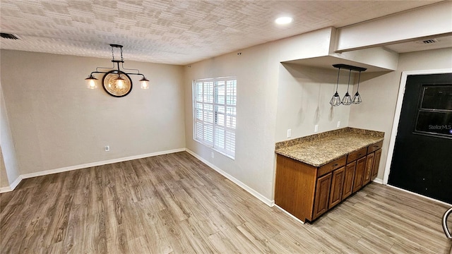 interior space with a textured ceiling and light wood-type flooring