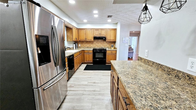 kitchen with decorative light fixtures, tasteful backsplash, stove, stainless steel refrigerator with ice dispenser, and light stone countertops