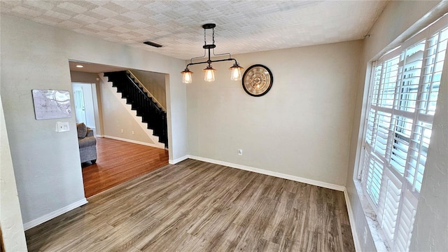 unfurnished room with hardwood / wood-style floors and a textured ceiling