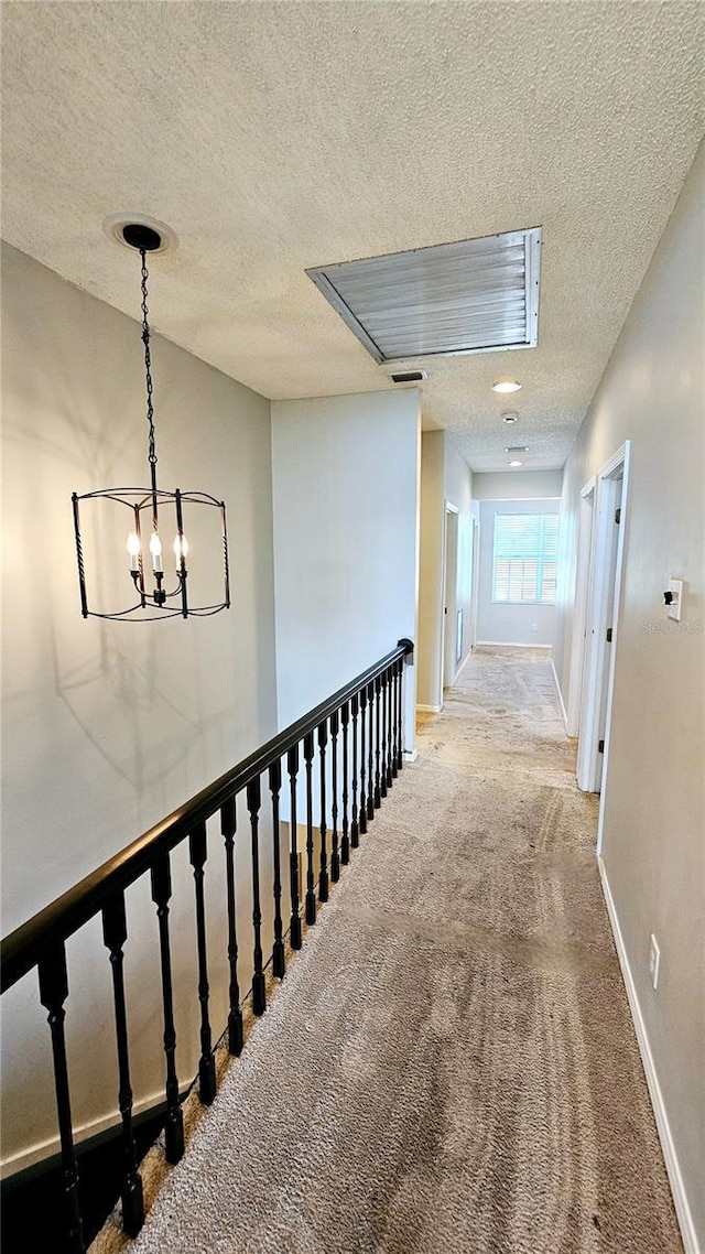 corridor featuring carpet and a textured ceiling