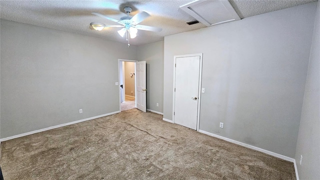 carpeted spare room with ceiling fan and a textured ceiling