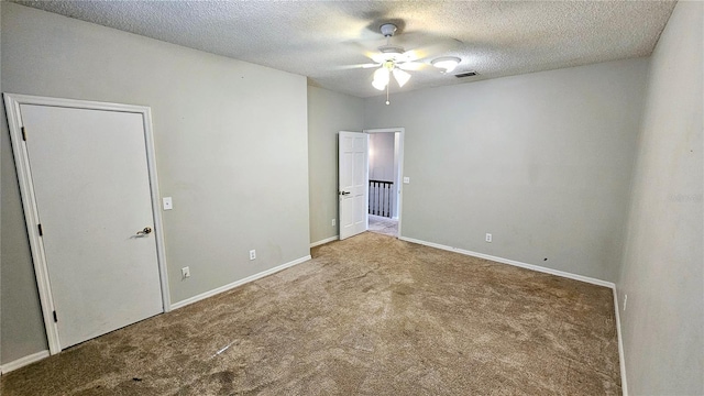 empty room with ceiling fan, carpet, and a textured ceiling