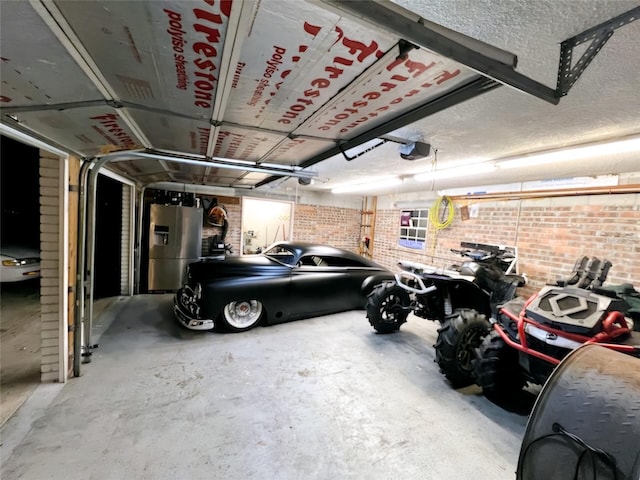 garage with a garage door opener and stainless steel fridge