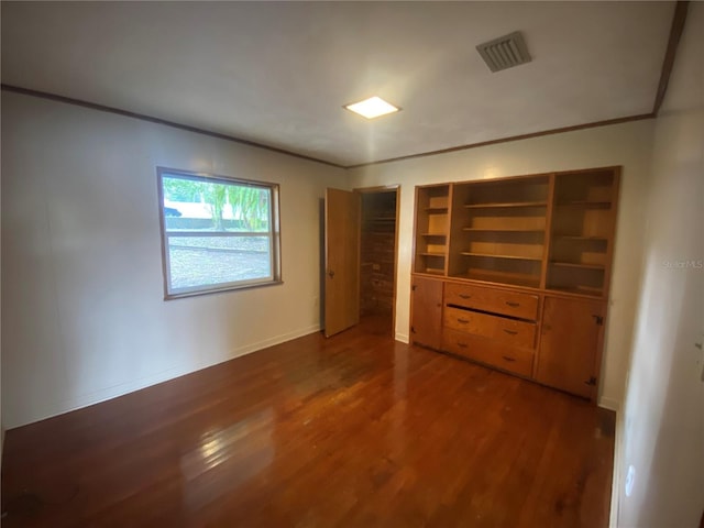 unfurnished bedroom featuring dark wood-type flooring and ornamental molding