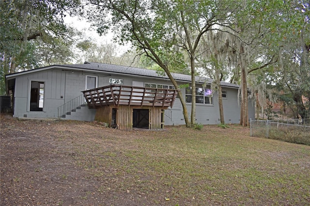 back of house featuring a wooden deck and a lawn