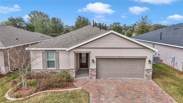 ranch-style home featuring a garage, central AC unit, and a front lawn