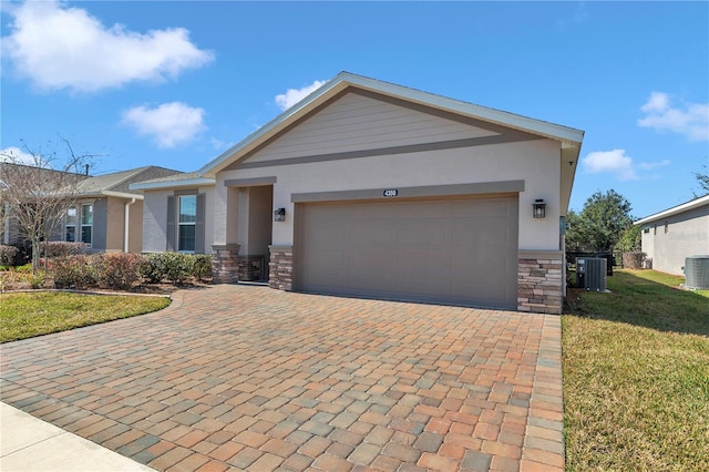 view of front of property featuring cooling unit, a garage, and a front yard