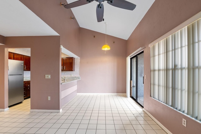 unfurnished room with lofted ceiling, light tile patterned floors, and ceiling fan