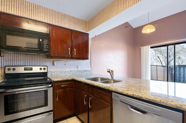 kitchen with sink, light stone counters, hanging light fixtures, appliances with stainless steel finishes, and kitchen peninsula