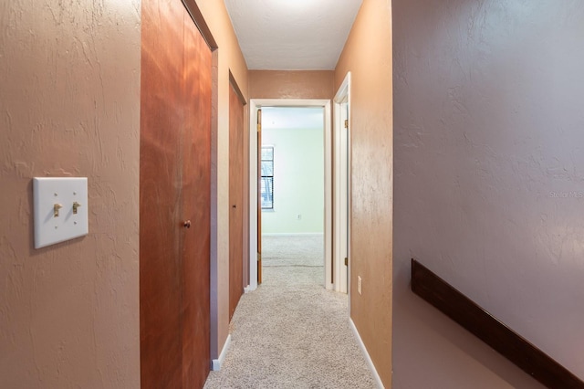 hallway with light colored carpet