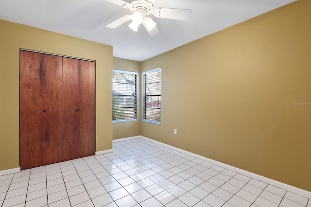 unfurnished bedroom featuring light tile patterned floors, ceiling fan, and a closet