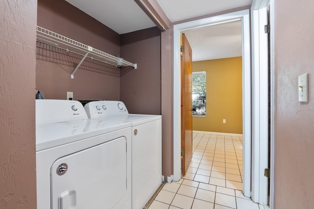 clothes washing area featuring separate washer and dryer and light tile patterned floors