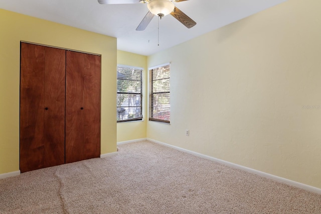 unfurnished bedroom with ceiling fan, a closet, and light carpet