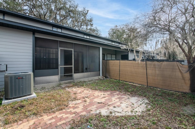 view of yard with a sunroom, a patio, and central air condition unit