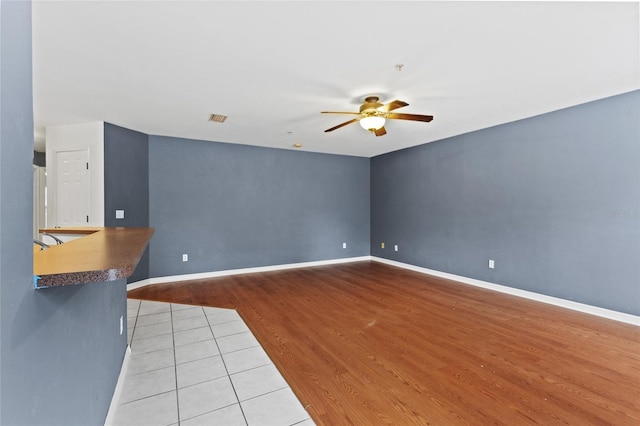 unfurnished living room with ceiling fan and light wood-type flooring