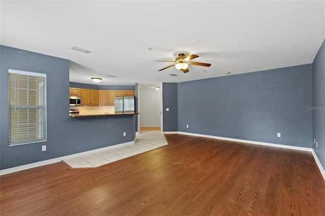 unfurnished living room with light hardwood / wood-style flooring and ceiling fan