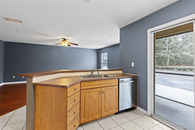 kitchen with sink, stainless steel dishwasher, light tile patterned floors, ceiling fan, and kitchen peninsula