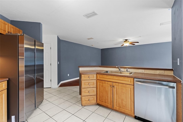 kitchen with sink, light tile patterned floors, ceiling fan, appliances with stainless steel finishes, and kitchen peninsula