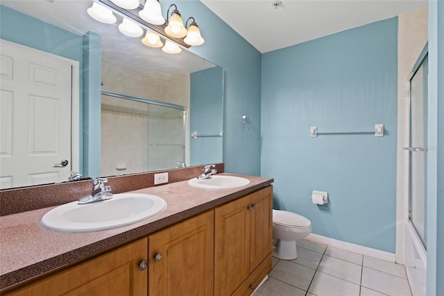 full bathroom with tile patterned flooring, vanity, bath / shower combo with glass door, and toilet