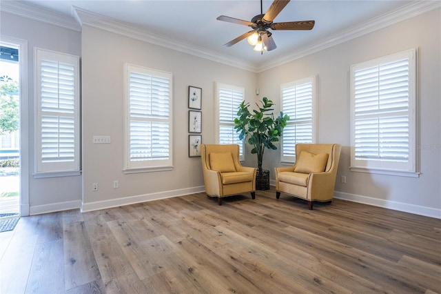 sitting room with baseboards, ceiling fan, light wood finished floors, and crown molding