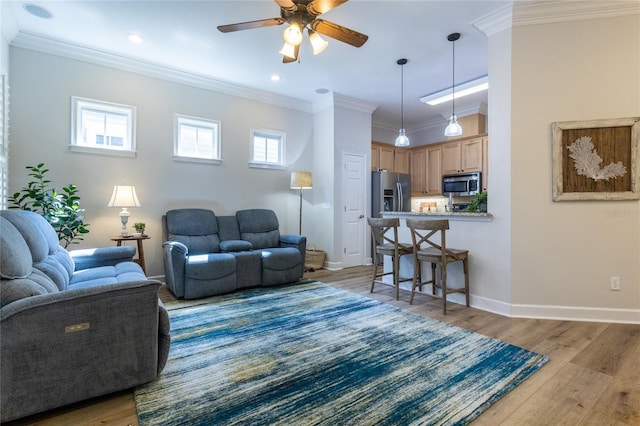 living room featuring light wood-style flooring, baseboards, ceiling fan, and ornamental molding