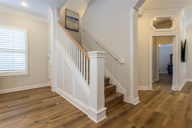 stairs with decorative columns, crown molding, baseboards, and wood finished floors