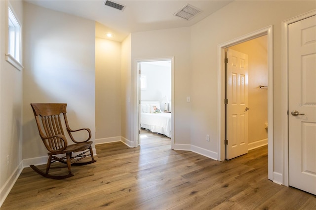 living area featuring wood finished floors, visible vents, and baseboards