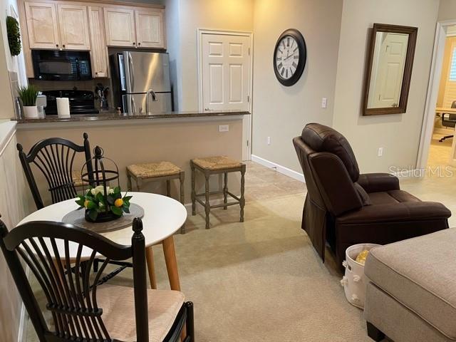 kitchen featuring dark countertops, black appliances, a peninsula, and baseboards