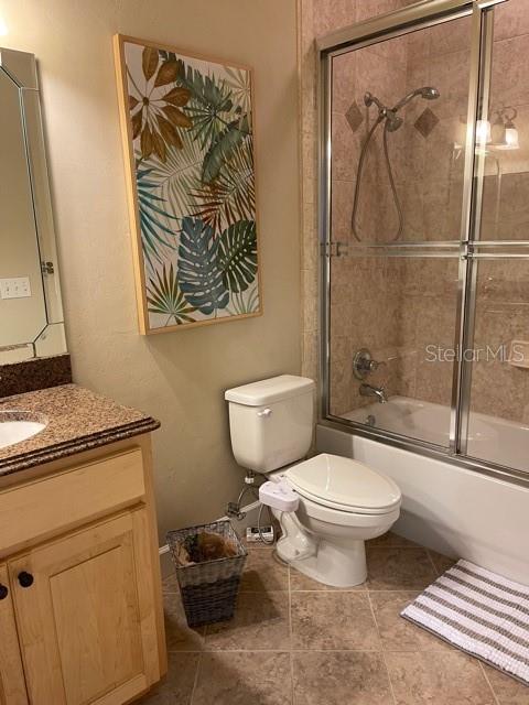 full bath with toilet, combined bath / shower with glass door, and vanity