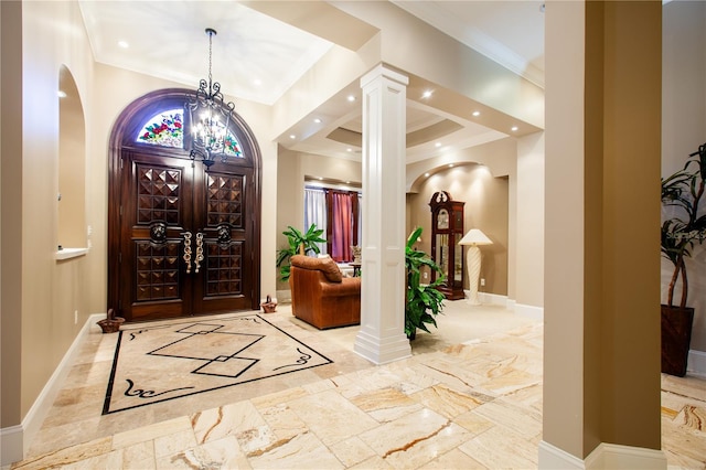 entryway with crown molding and ornate columns