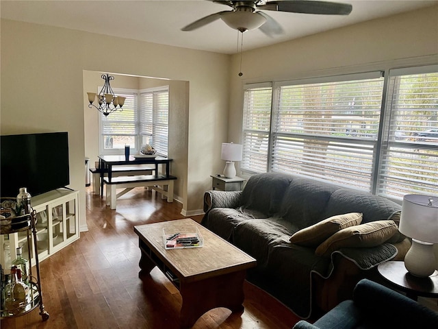 living room featuring ceiling fan with notable chandelier and dark hardwood / wood-style floors