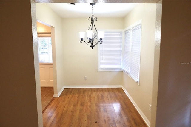 2704 NW 1st Ave, Gainesville, FL 32607 - unfurnished dining area featuring wood finished floors and a chandelier