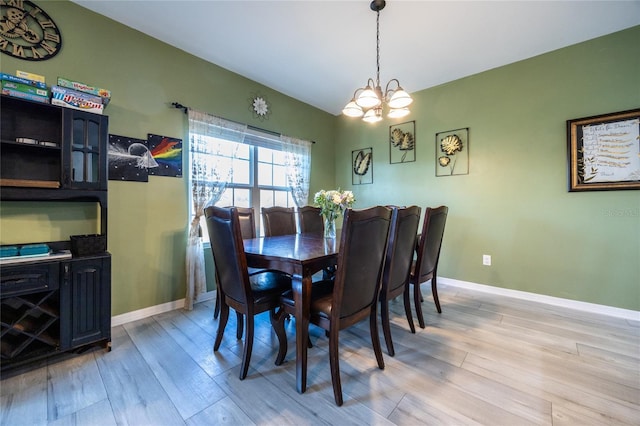 dining room featuring lofted ceiling, a notable chandelier, and light hardwood / wood-style floors