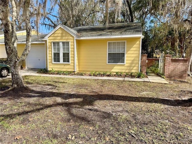 view of front of home featuring an attached garage and fence