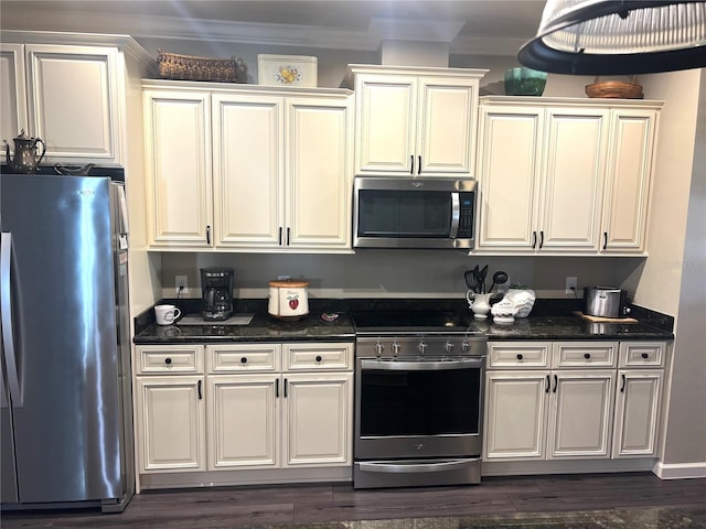 kitchen featuring appliances with stainless steel finishes, dark stone counters, ornamental molding, and dark wood-style floors