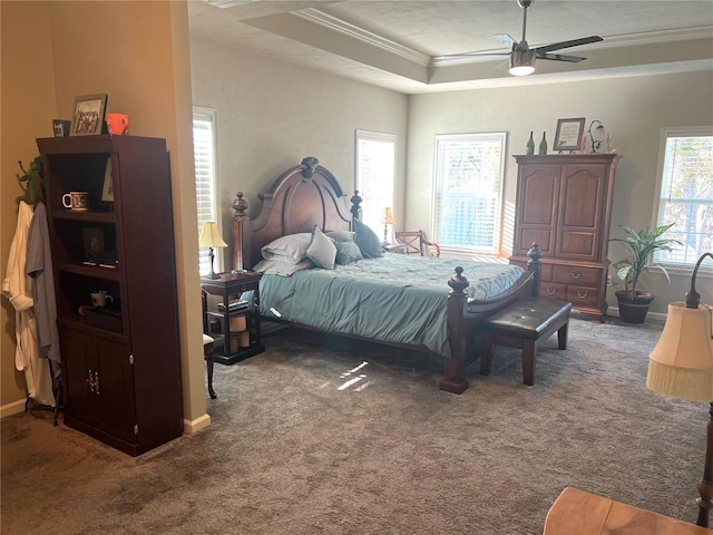 bedroom featuring carpet floors, a ceiling fan, baseboards, a raised ceiling, and crown molding