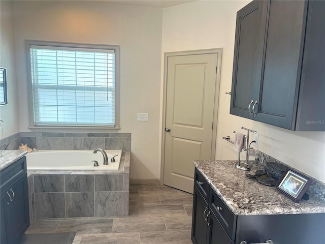 bathroom with a garden tub and vanity